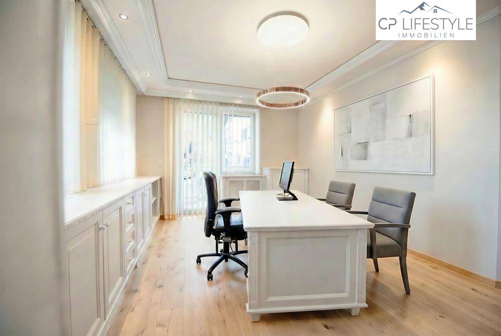 Geräumiges Büro mit klassischem Schreibtisch, ergonomischen Stühlen und integrierten Schränken unter den Fenstern.
