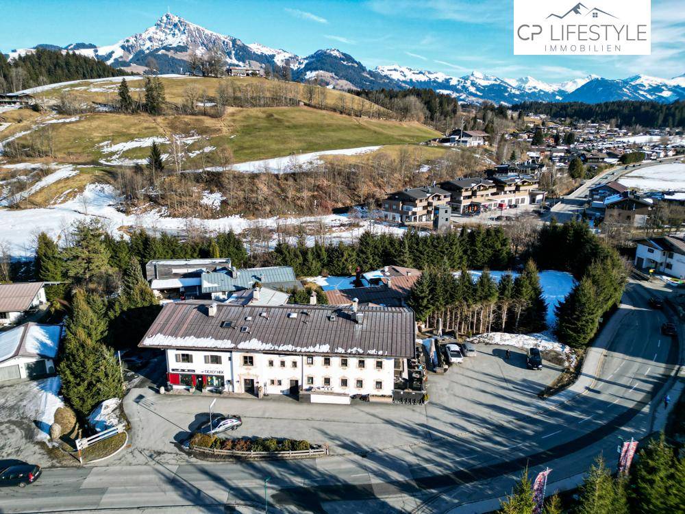 Luftaufnahme eines traditionellen Gebäudes mit Satteldach und umliegender Winterlandschaft.