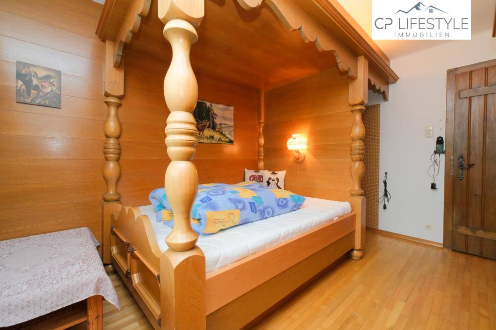 Traditionelles Schlafzimmer mit Himmelbett aus Holz und Holzboden.