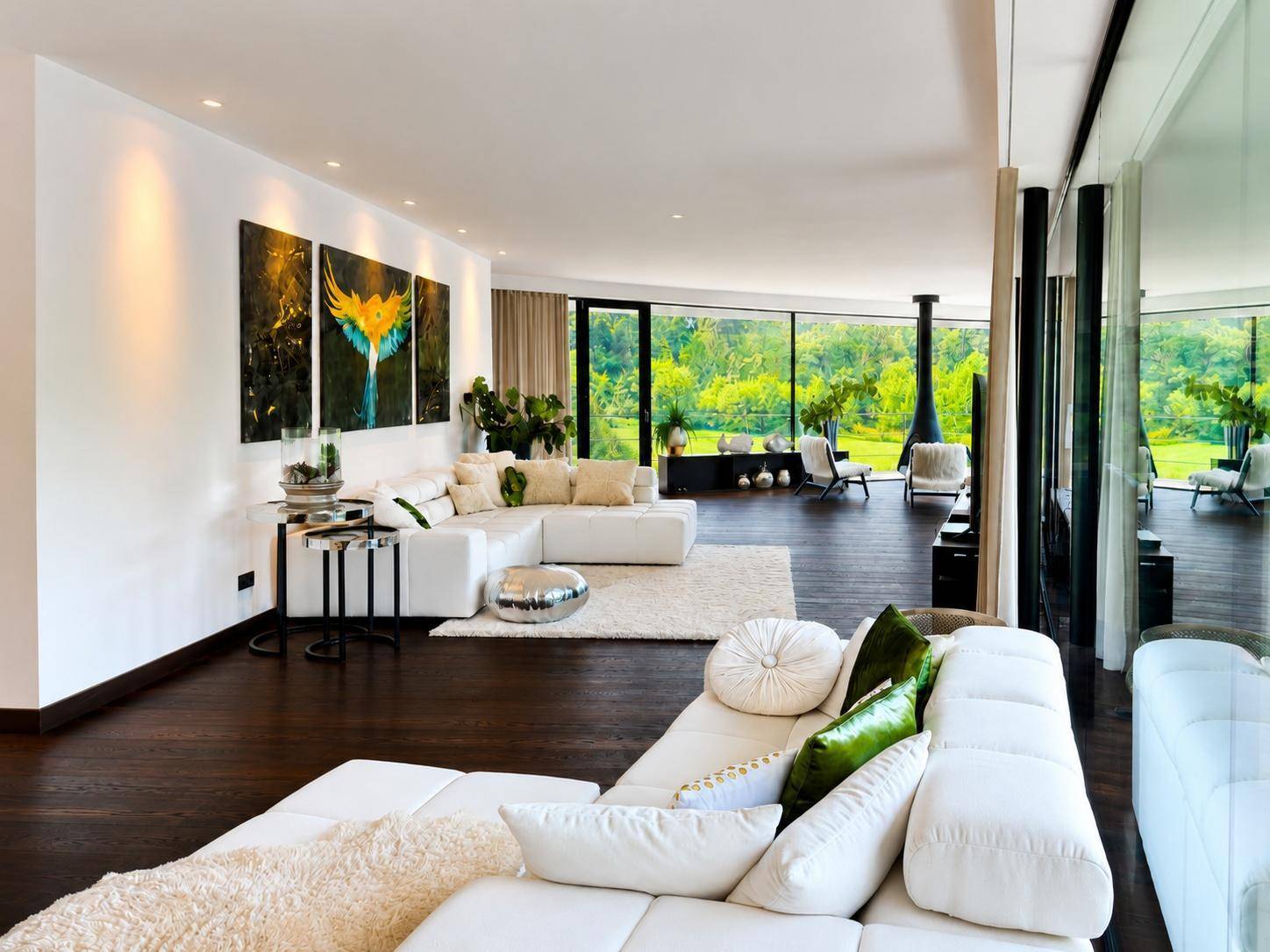 Großzügiges Wohnzimmer mit weißen Sofas, Holzboden und raumhohen Fenstern mit Panoramablick.
