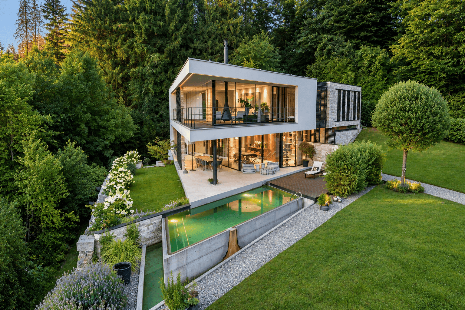 Luxuriöse Villa mit Infinity-Pool, großzügiger Terrasse und weitläufigem Garten, umgeben von Wald.