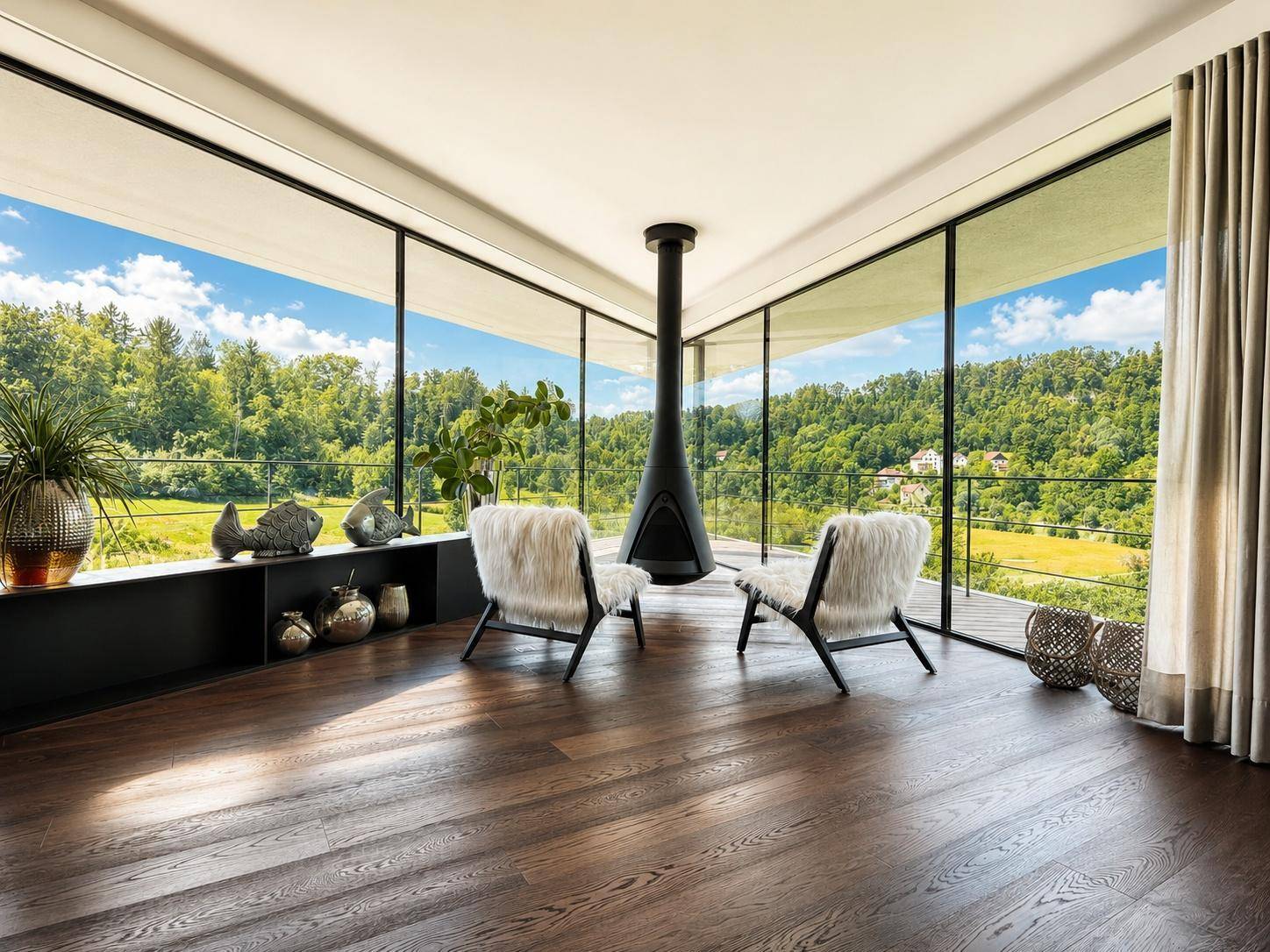 Gemütlicher Lounge-Bereich mit Hängesessel-Kamin, Holzboden und raumhohen Fenstern mit Weitblick.