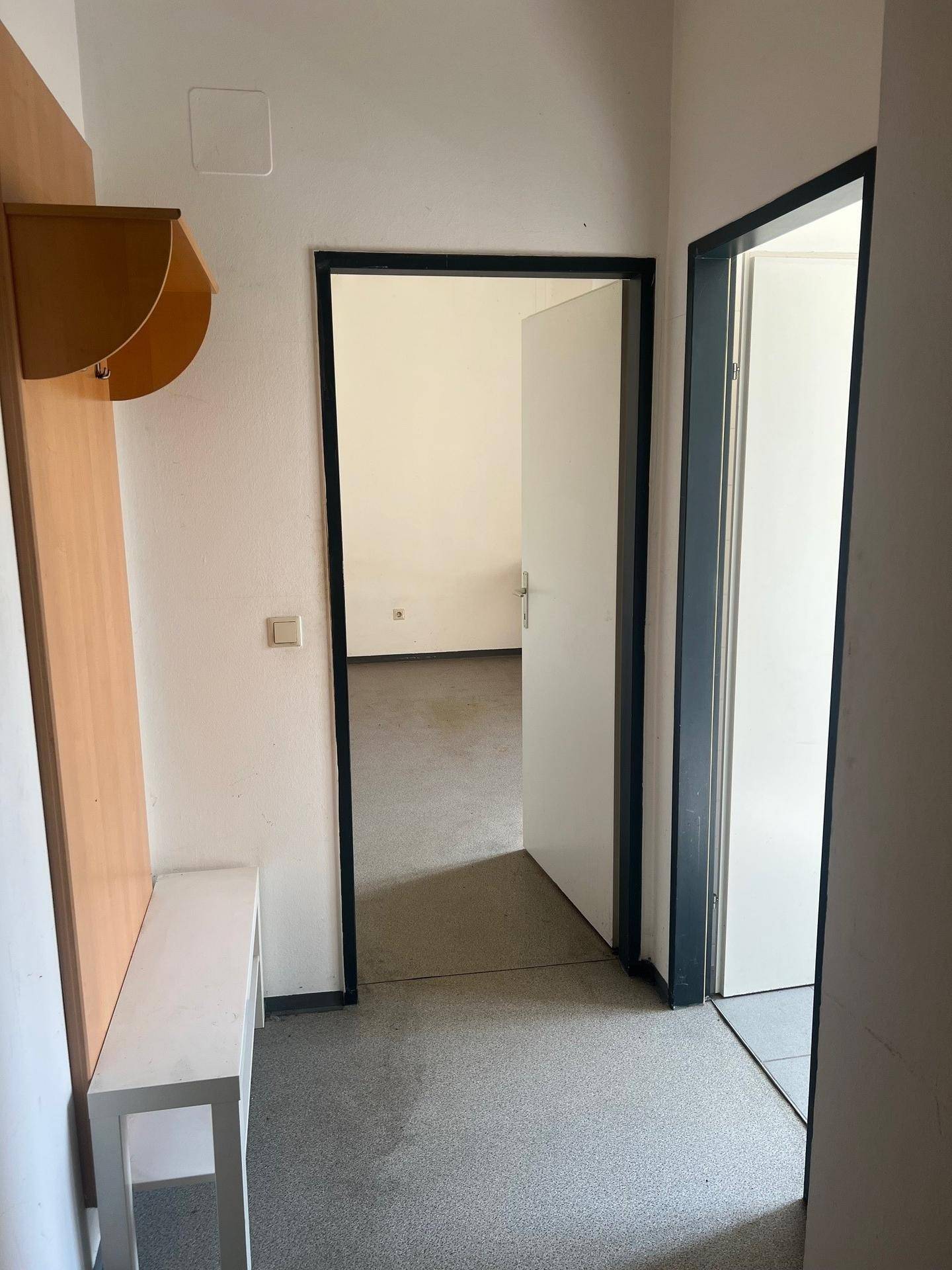 Heller Eingangsbereich mit Garderobe und Zugang zu angrenzenden Räumen.