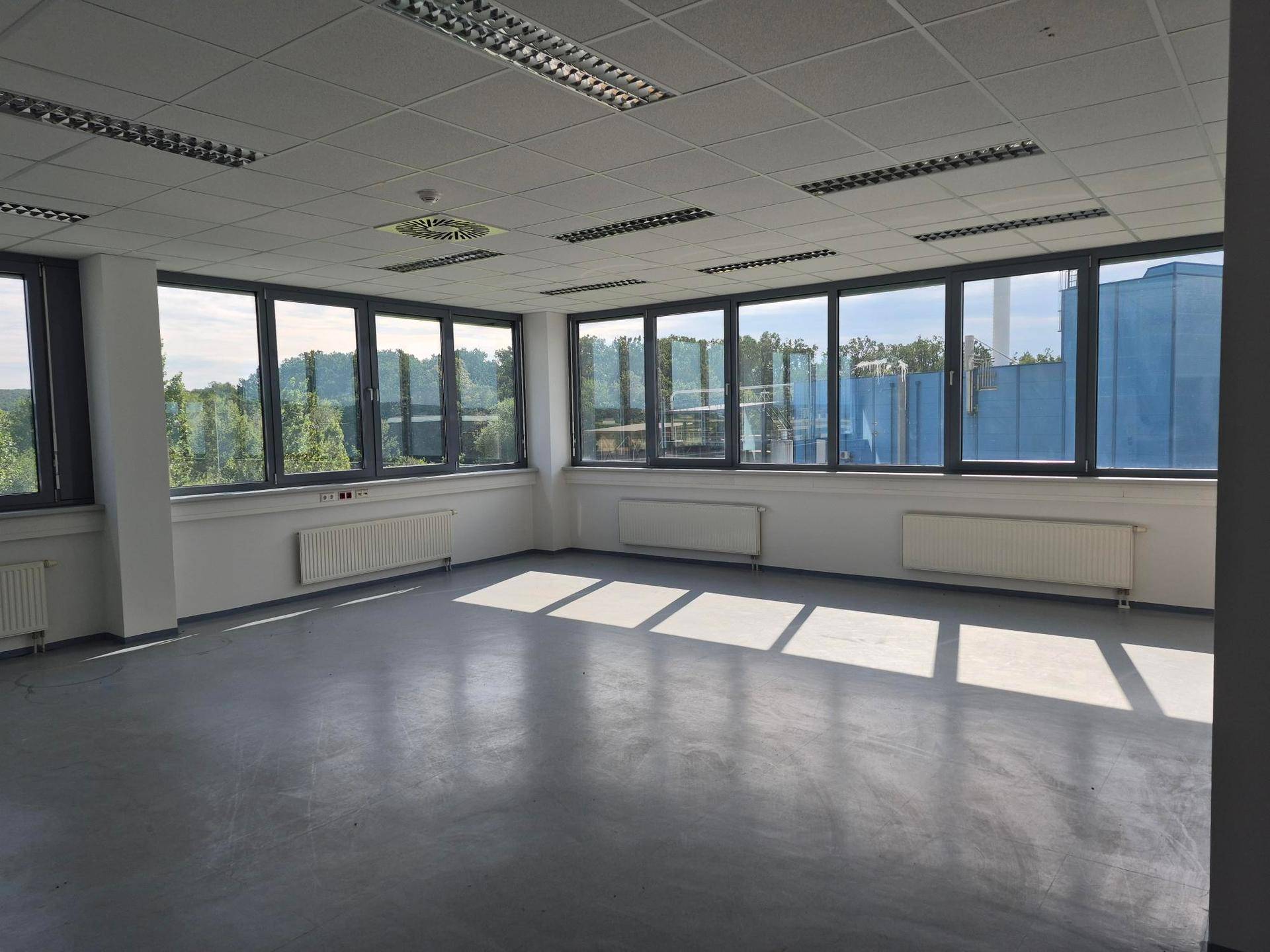 Großer, heller Eckbüroraum mit vielen Fenstern, die viel Tageslicht hereinlassen und eine weite Aussicht bieten.