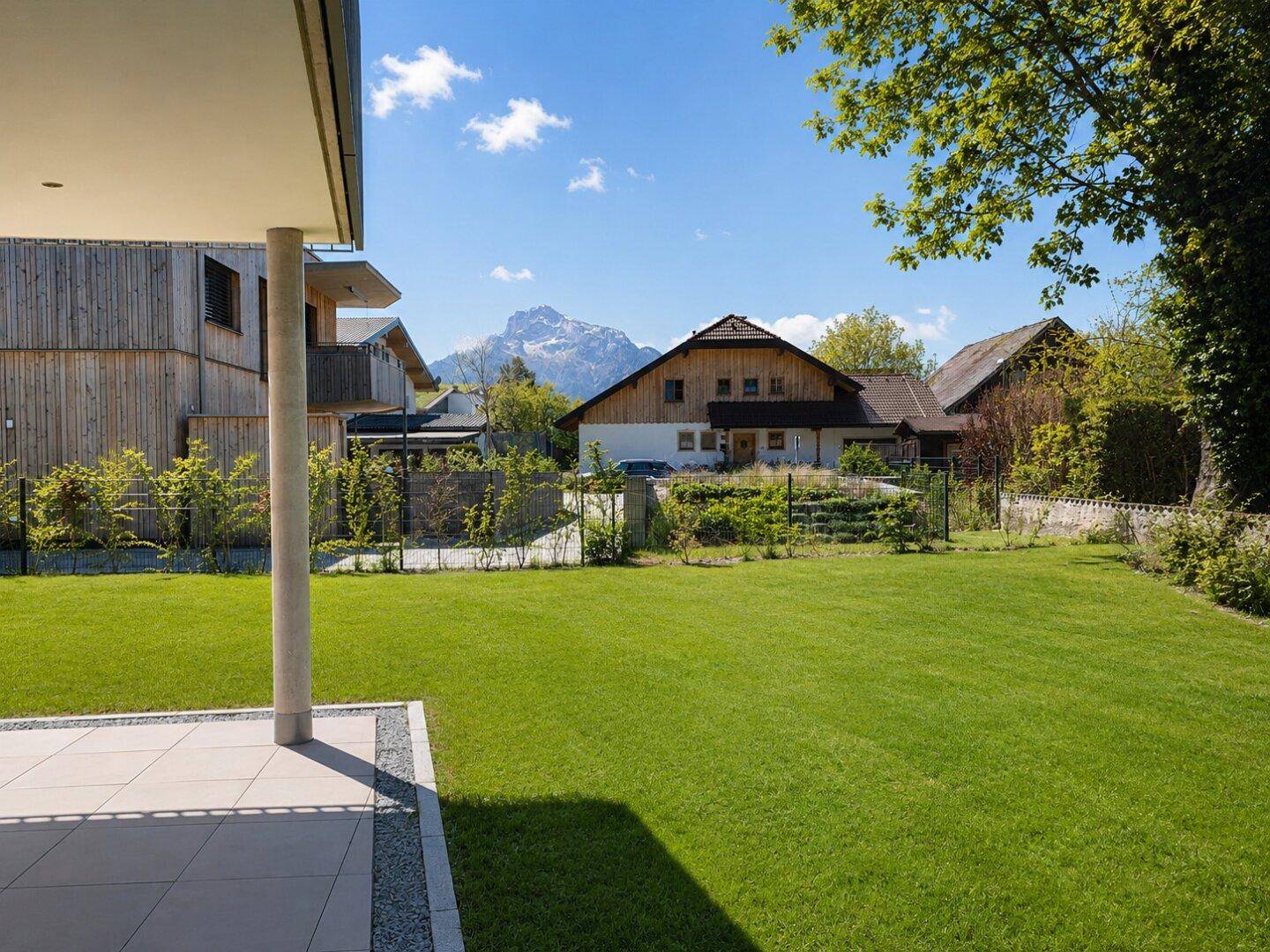 Gepflegter Gartenbereich mit Rasenfläche und Blick auf die umliegende Berglandschaft.