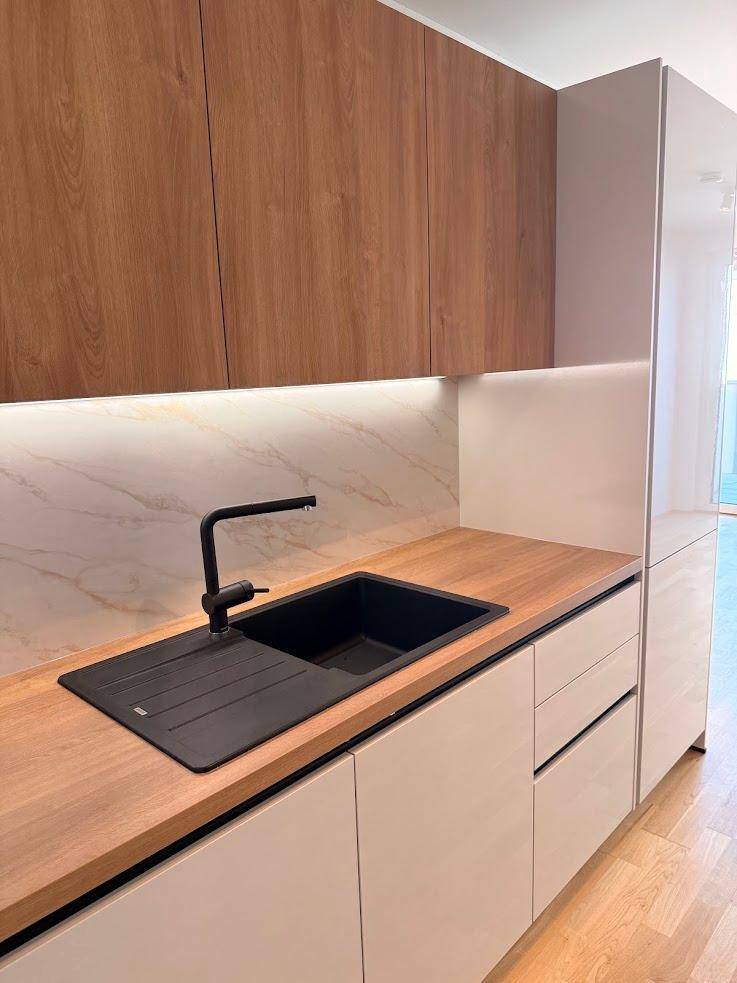 Stilvolle Küche mit schwarzer Spüle, passendem Wasserhahn und Holz-Arbeitsplatte.