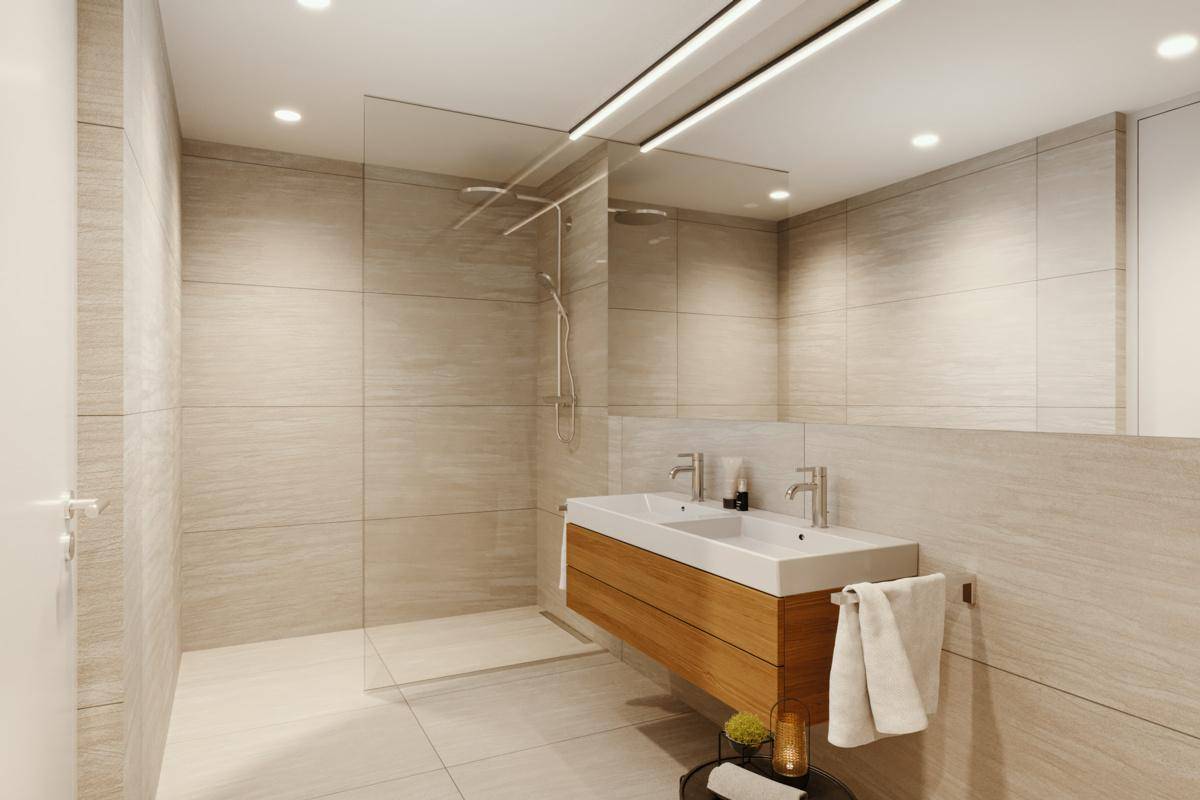 Modernes Badezimmer mit doppelten Waschbecken, großer begehbarer Dusche und hellen Fliesen.