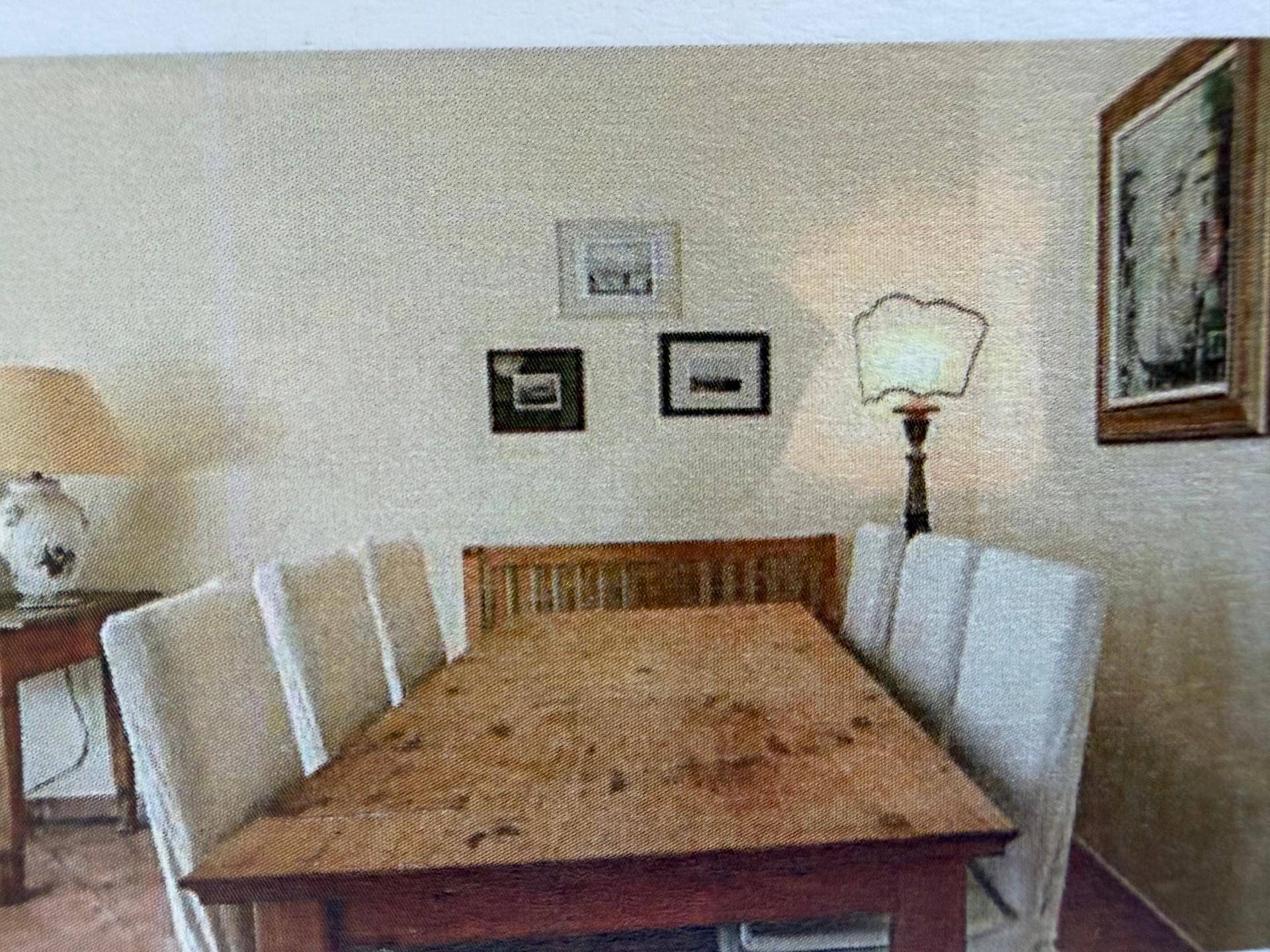 Gemütlicher Essbereich mit Holztisch und gepolsterten Stühlen, beleuchtet von einer Stehlampe.