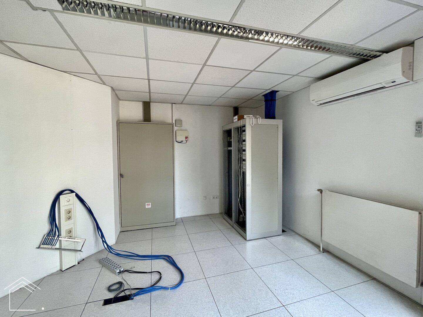 Technikraum mit Serverracks, Verkabelung und Klimaanlage, wichtig für die Infrastruktur.