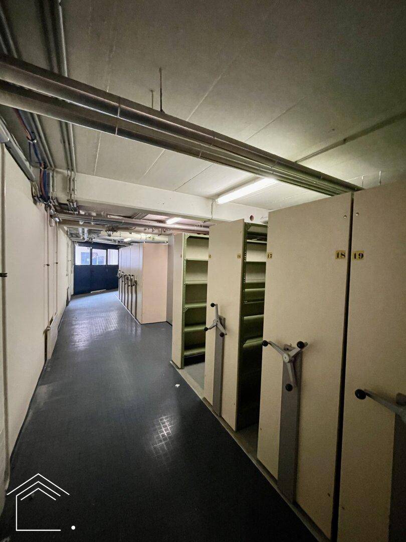 Langer Kellergang mit mobilen Regalsystemen, ideal für Archivierung und Lagerung.