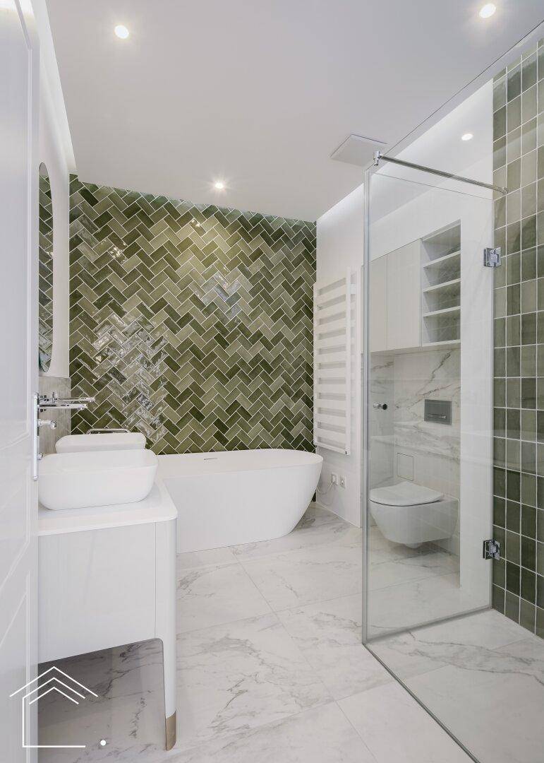 Luxuriöses Badezimmer mit freistehender Badewanne, begehbarer Dusche und grünen Fliesen.
