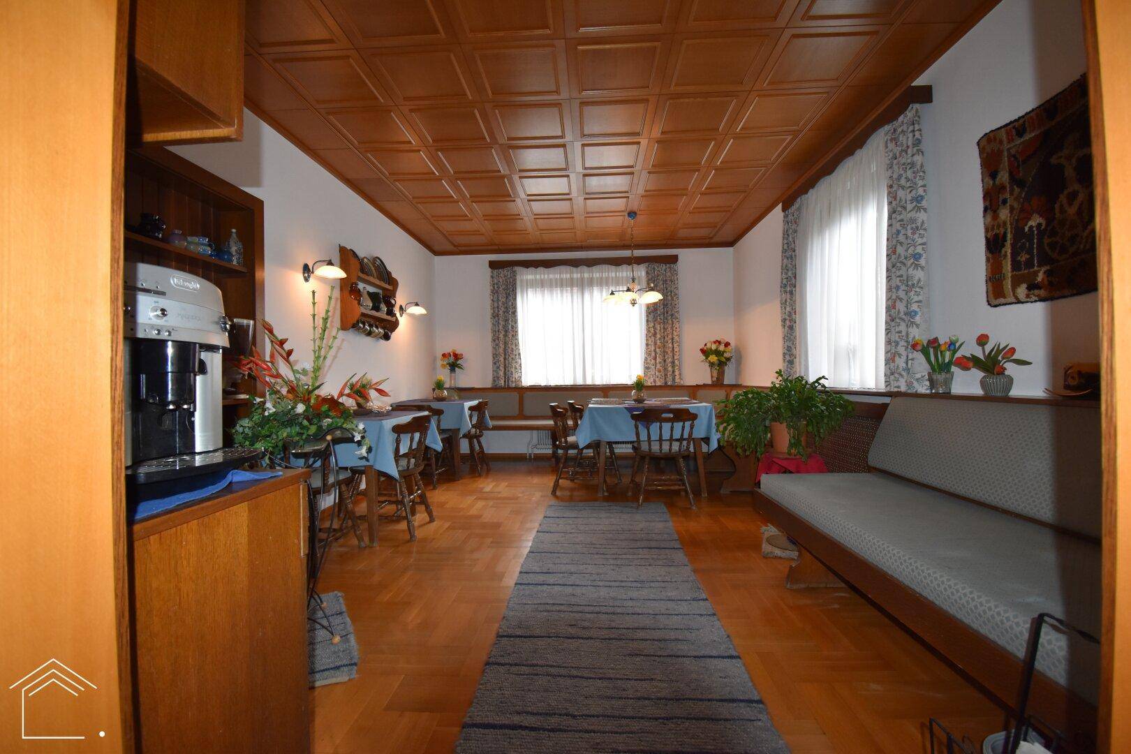 Traditionelles Esszimmer mit Holzvertäfelung, Kassettendecke und Parkettboden, ideal für gesellige Runden.