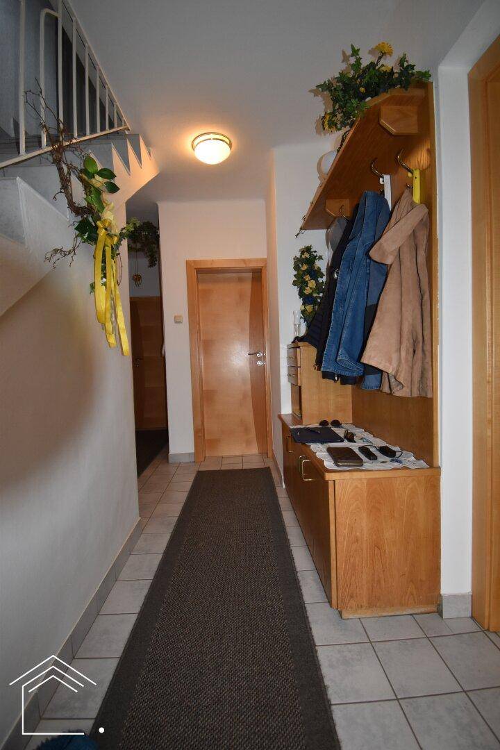 Geräumiger Flur mit Garderobe, Fliesenboden und Zugang zu weiteren Räumen.