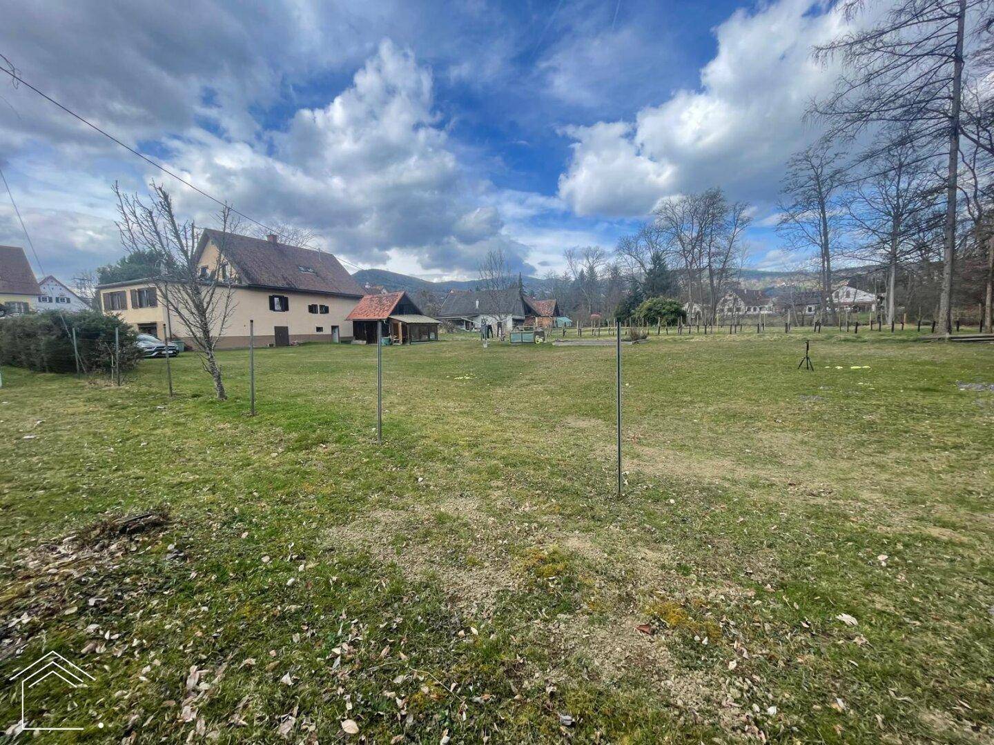 Große Gartenfläche mit Blick auf das Hauptgebäude und die weite Landschaft.