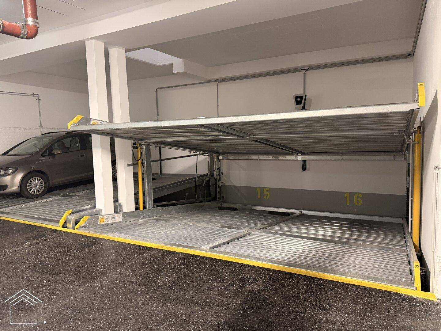 Detailansicht des Doppelparker-Systems in der Tiefgarage mit einem geparkten Fahrzeug auf der oberen Plattform.
