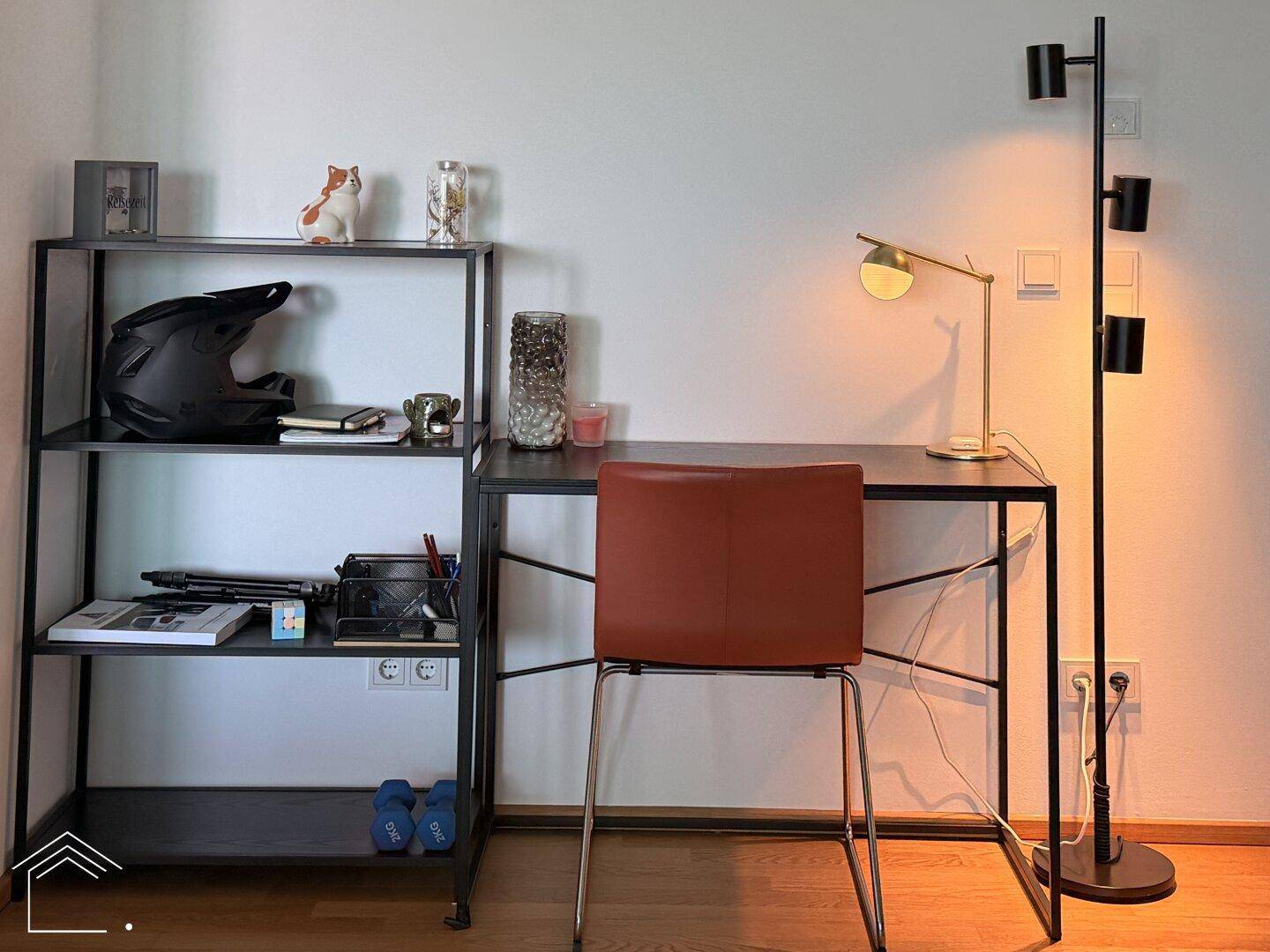 Moderner Arbeitsbereich mit Schreibtisch, Stuhl und Regal, gut beleuchtet für konzentriertes Arbeiten.