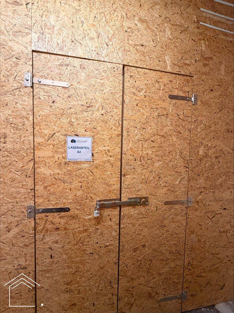 Zwei Lagertüren aus OSB-Platten mit Riegeln und einem Schild "Lagerabteil A2".