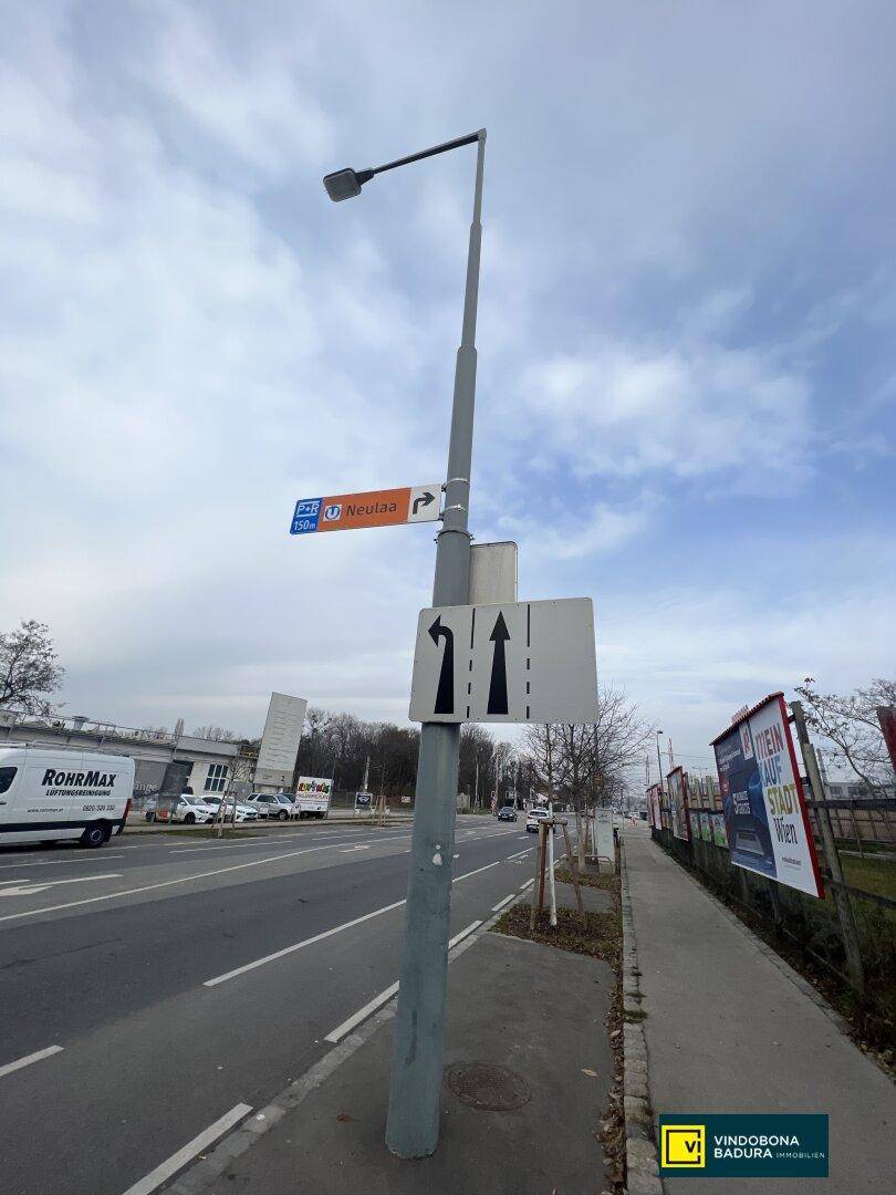 Straßenszene mit Verkehrsschildern und Bushaltestelle, die die lokale Infrastruktur hervorhebt.