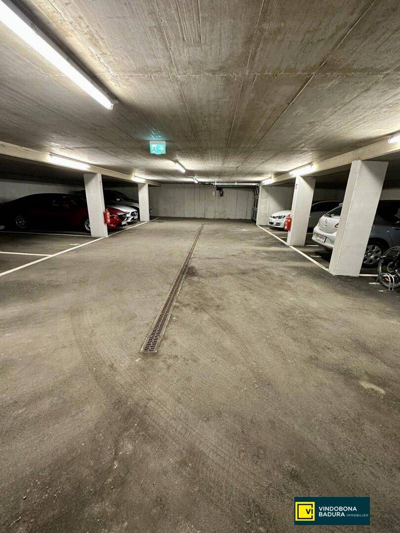 Geräumige Tiefgarage mit mehreren Stellplätzen und Beleuchtung, ideal für Bewohner und Besucher.