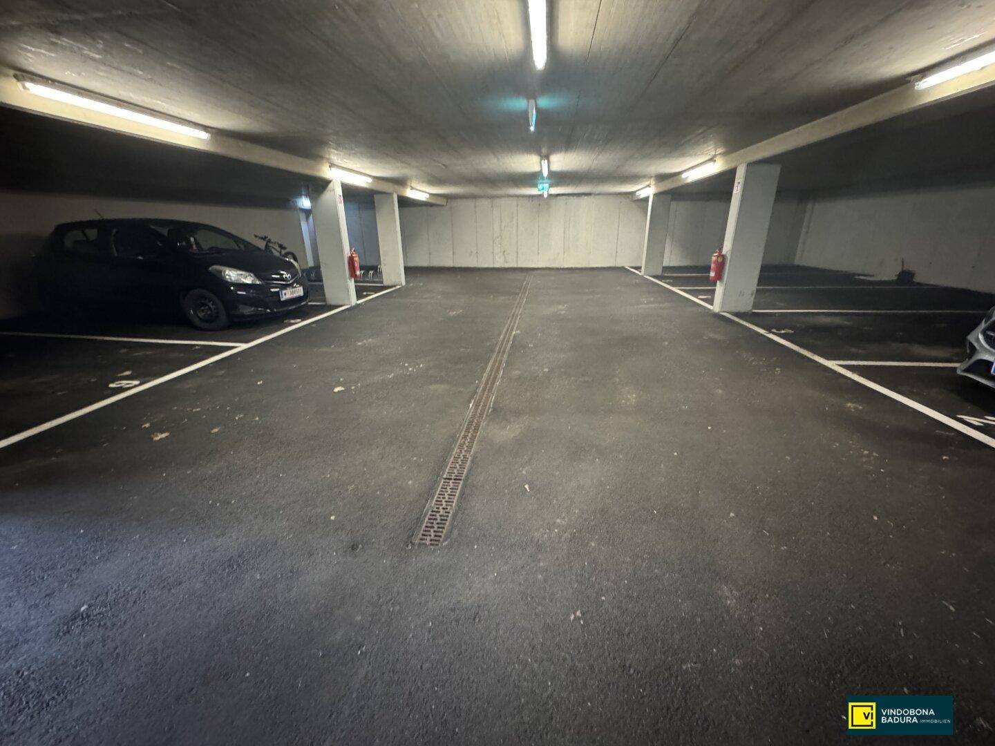 Helle und saubere Tiefgarage mit markierten Stellplätzen und guter Beleuchtung.