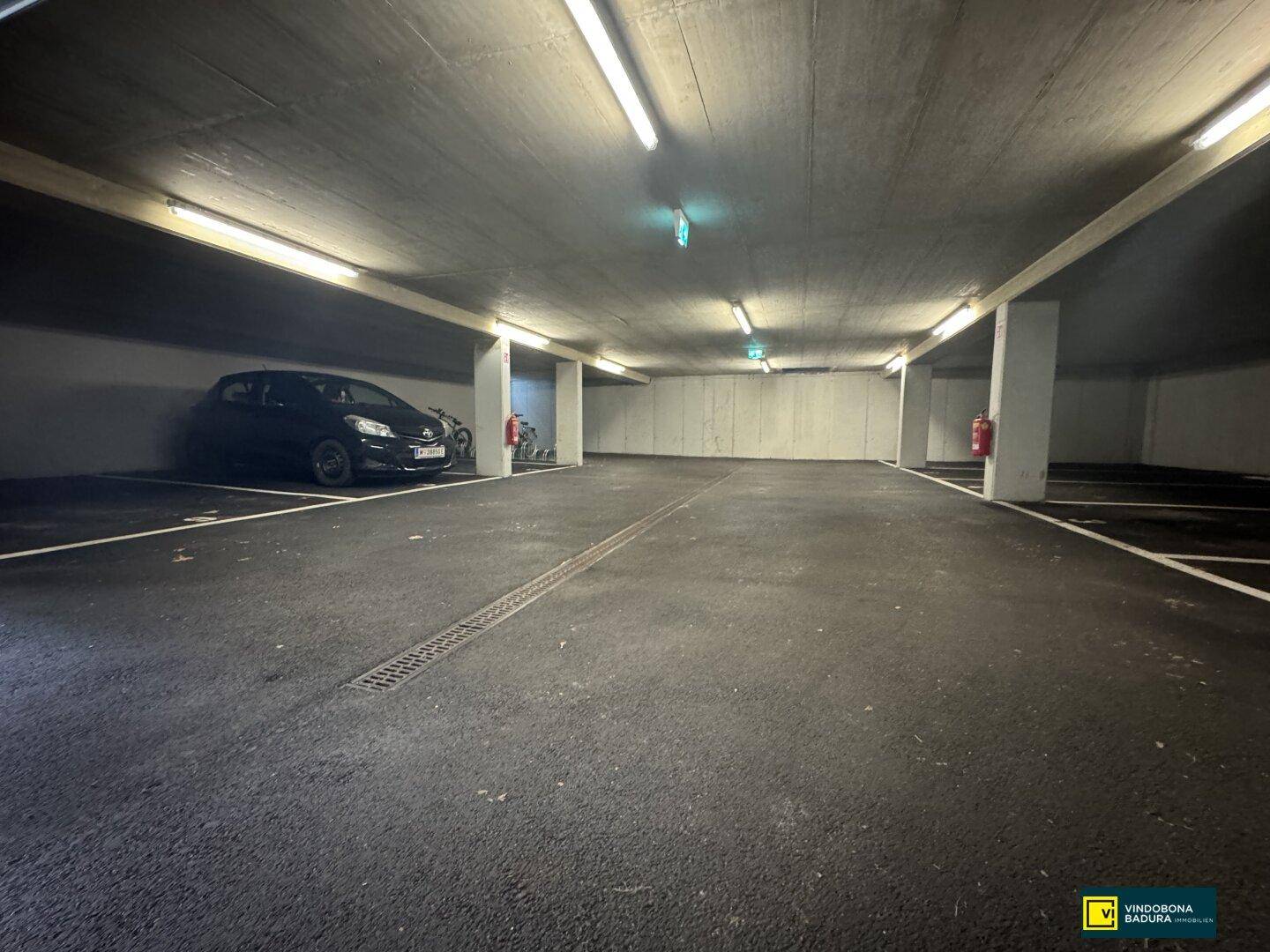 Weitläufige Tiefgarage mit ausreichend Platz und klar markierten Parkbuchten für Fahrzeuge.