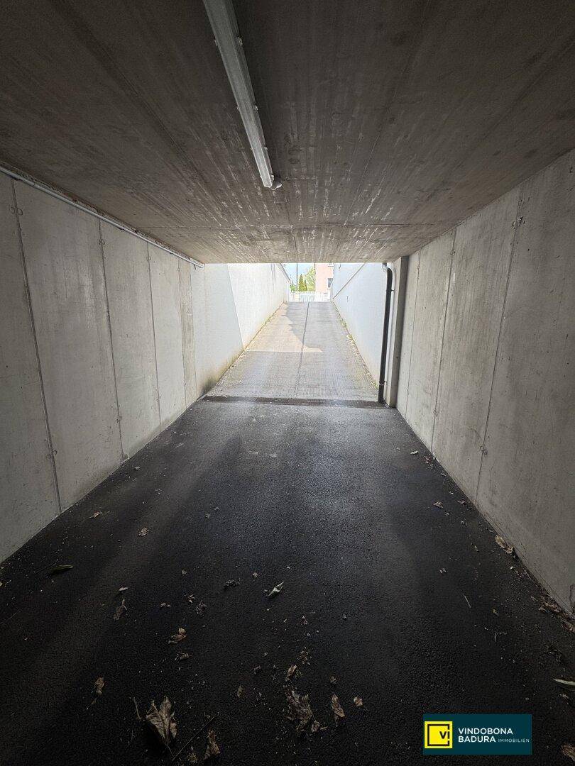 Zufahrtsrampe zur Tiefgarage, die aus dem Untergeschoss ins Freie führt und gut beleuchtet ist.
