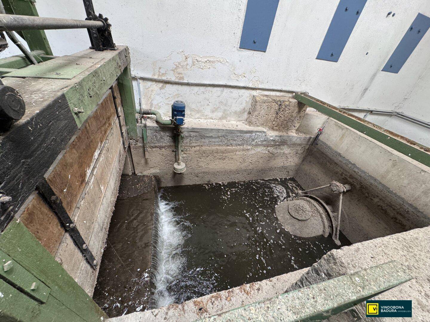 Industrielle Anlage mit Wasserbecken und mechanischen Komponenten, möglicherweise für Verarbeitungsprozesse.