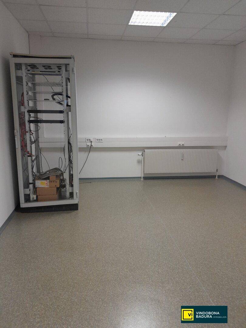 Technischer Raum mit einem Serverschrank und Vinylboden, ideal für IT-Infrastruktur und Verkabelung.