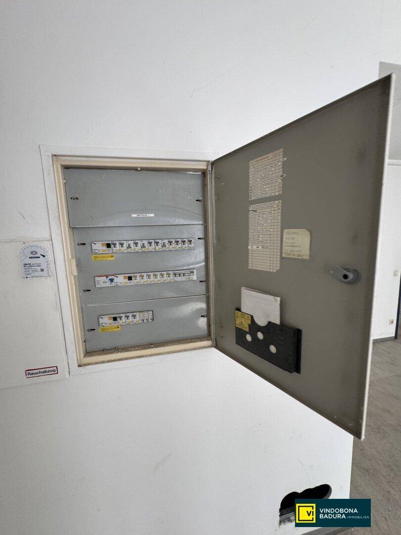 Offener Sicherungskasten an der Wand, zeigt die elektrische Hauptverteilung des Gebäudes.