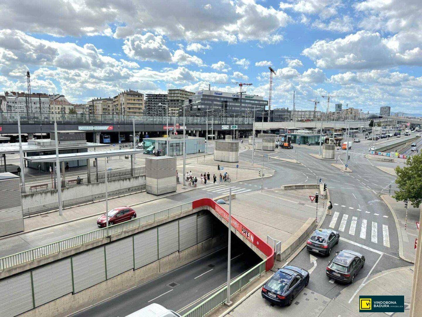 Weitläufiger Blick auf die städtische Umgebung des Wiener Hauptbahnhofs mit Straßen und Verkehr.