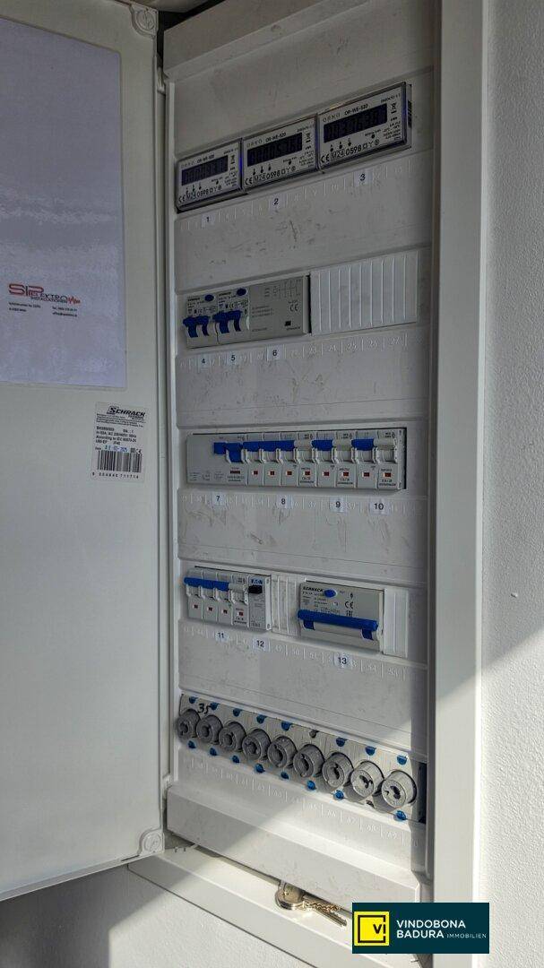 Offener Sicherungskasten mit mehreren Schaltern und Zählern, für die elektrische Verteilung.