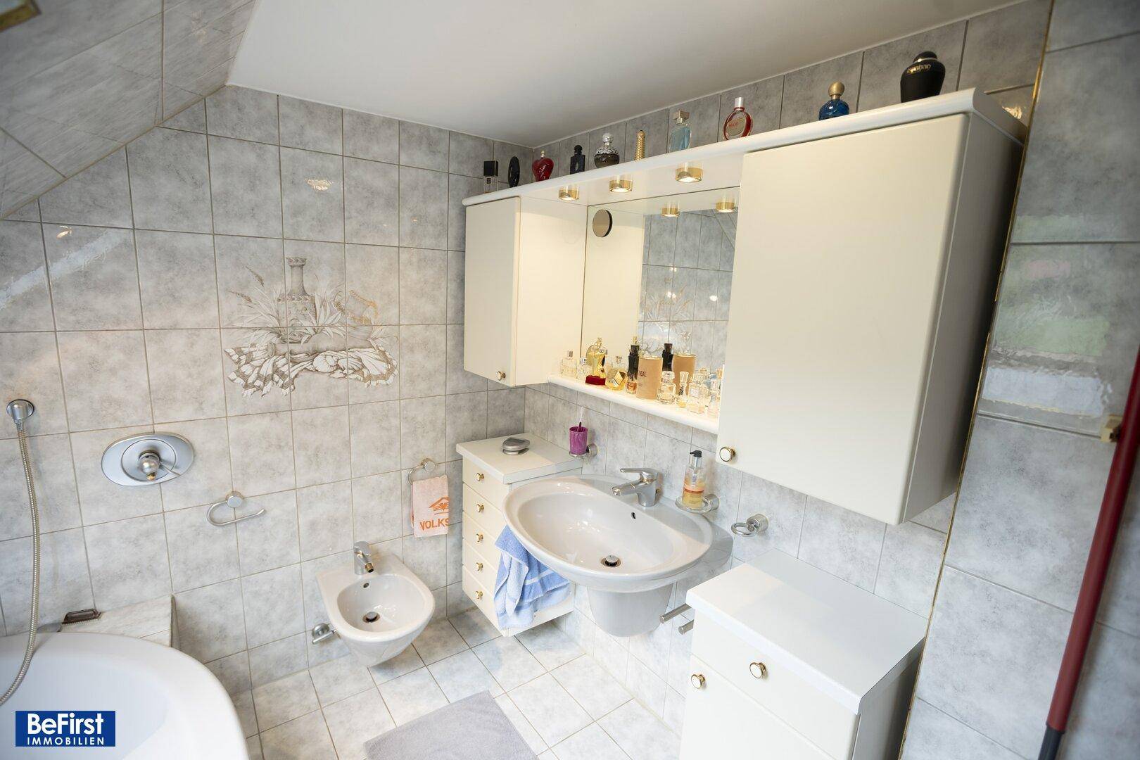 Funktionales Badezimmer mit Badewanne, Bidet, Waschbecken und Spiegelschrank.
