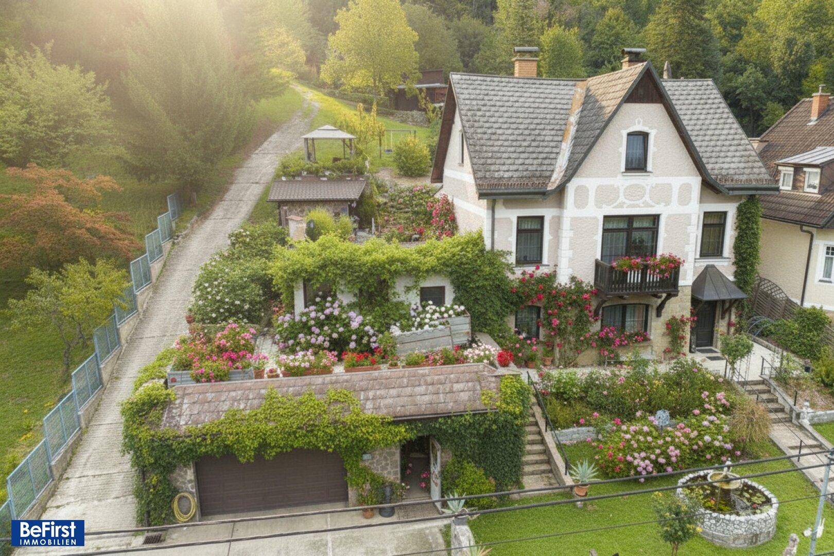 Malerisches Anwesen mit großem Garten, üppiger Vegetation, Garage und einem charmanten Haus.