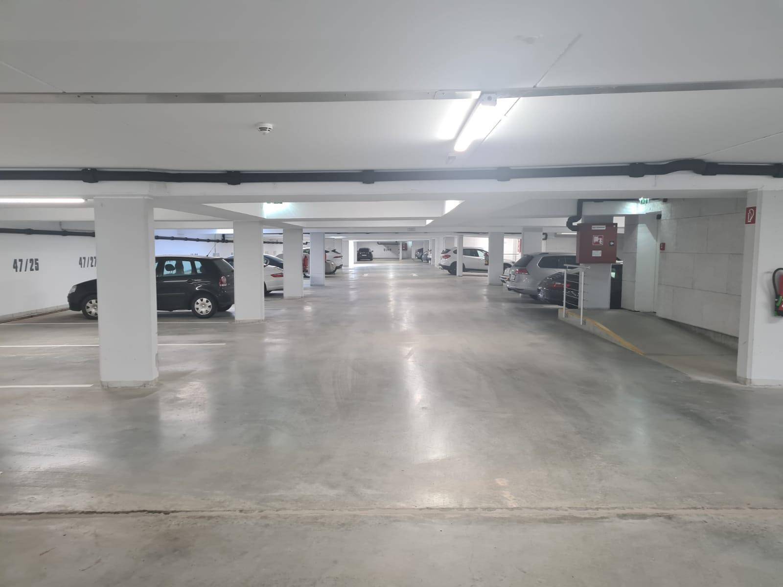 Helle und saubere Tiefgarage mit zahlreichen Parkplätzen und moderner Beleuchtung für Sicherheit und Komfort.