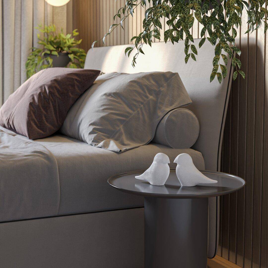 Gemütliches Schlafzimmerdetail mit bequemen Kissen, Nachttisch und grünen Pflanzen als Dekoration.