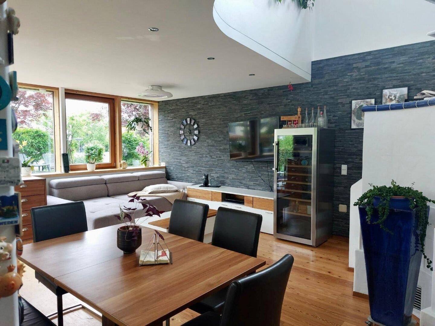 Geräumiger Wohn- und Essbereich mit Holztisch, Sofa und Schieferwand, ideal für gesellige Abende.