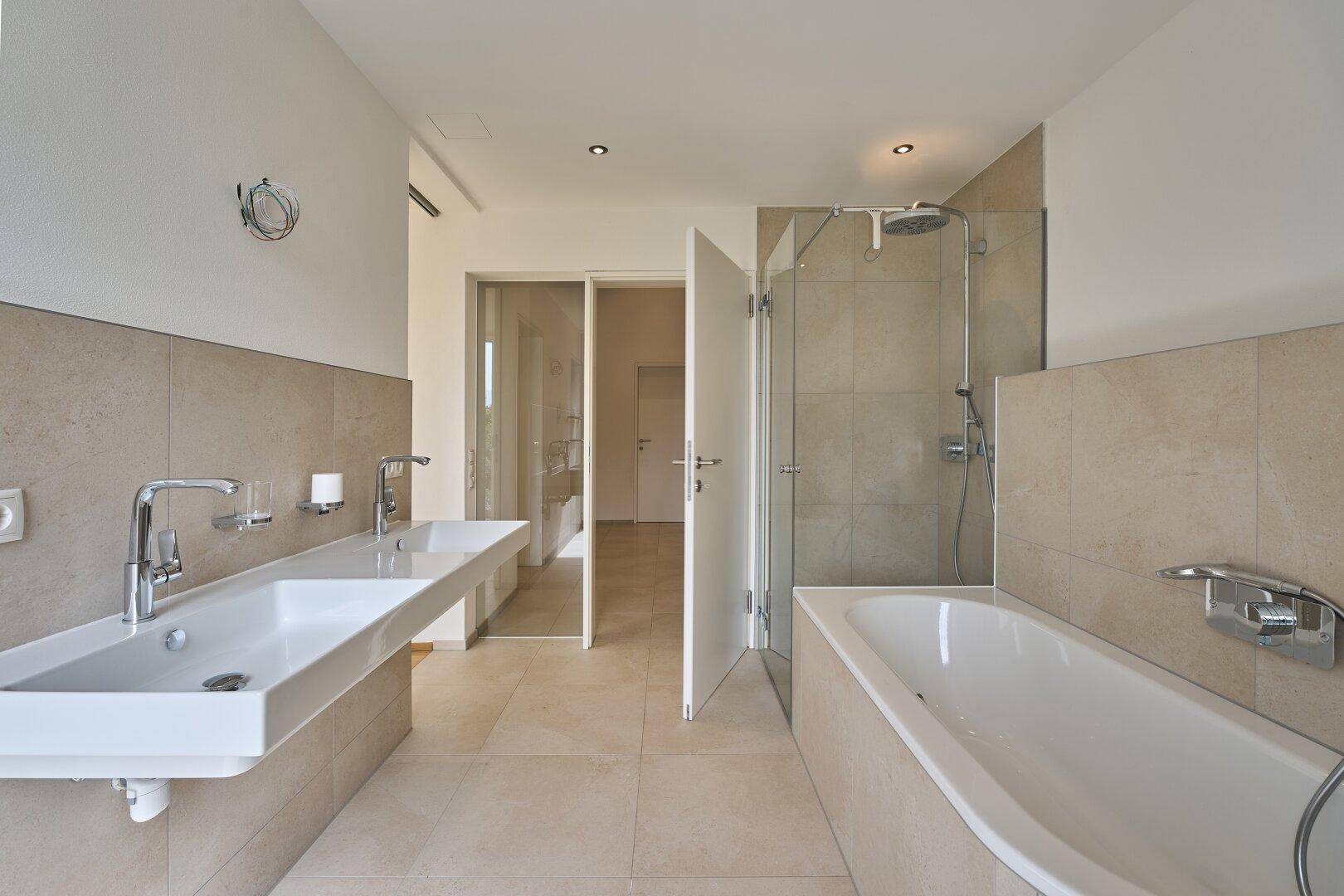 Modernes Badezimmer mit Doppelwaschbecken, Badewanne und begehbarer Dusche.