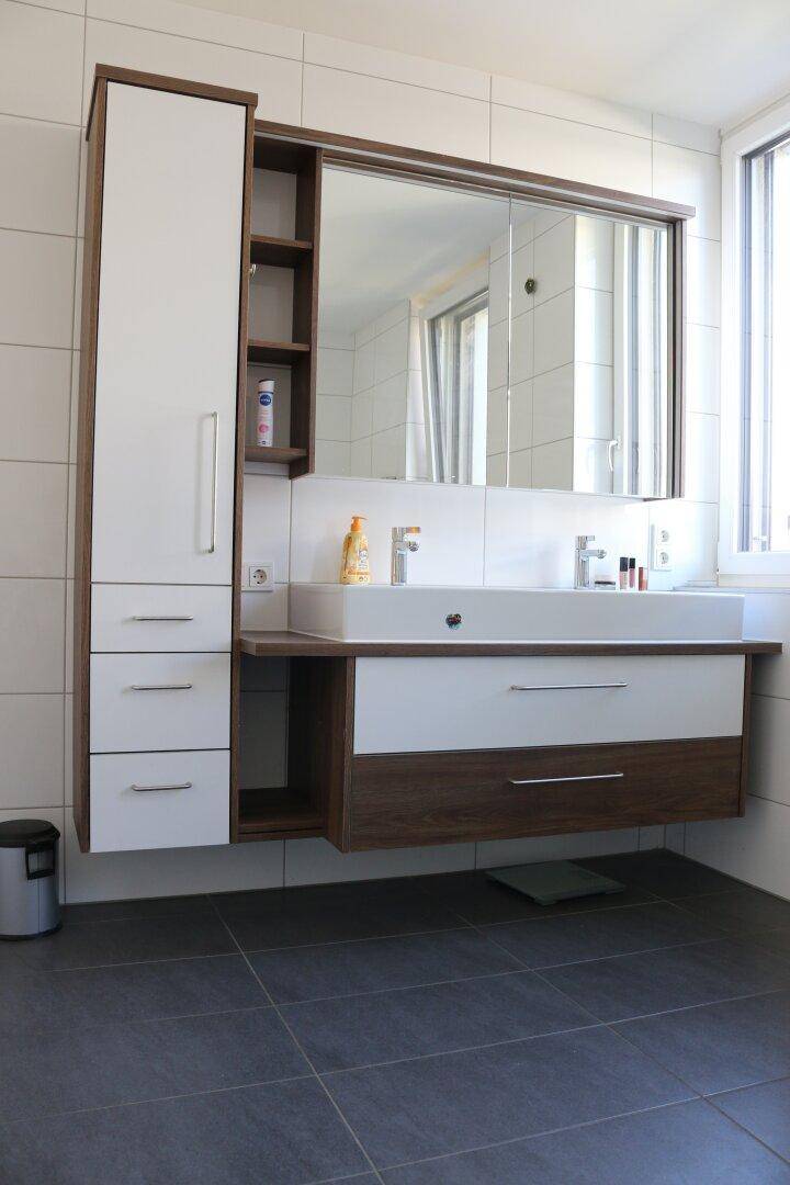 Modernes Badezimmer mit Doppelwaschbecken, großem Spiegelschrank und Fenster.