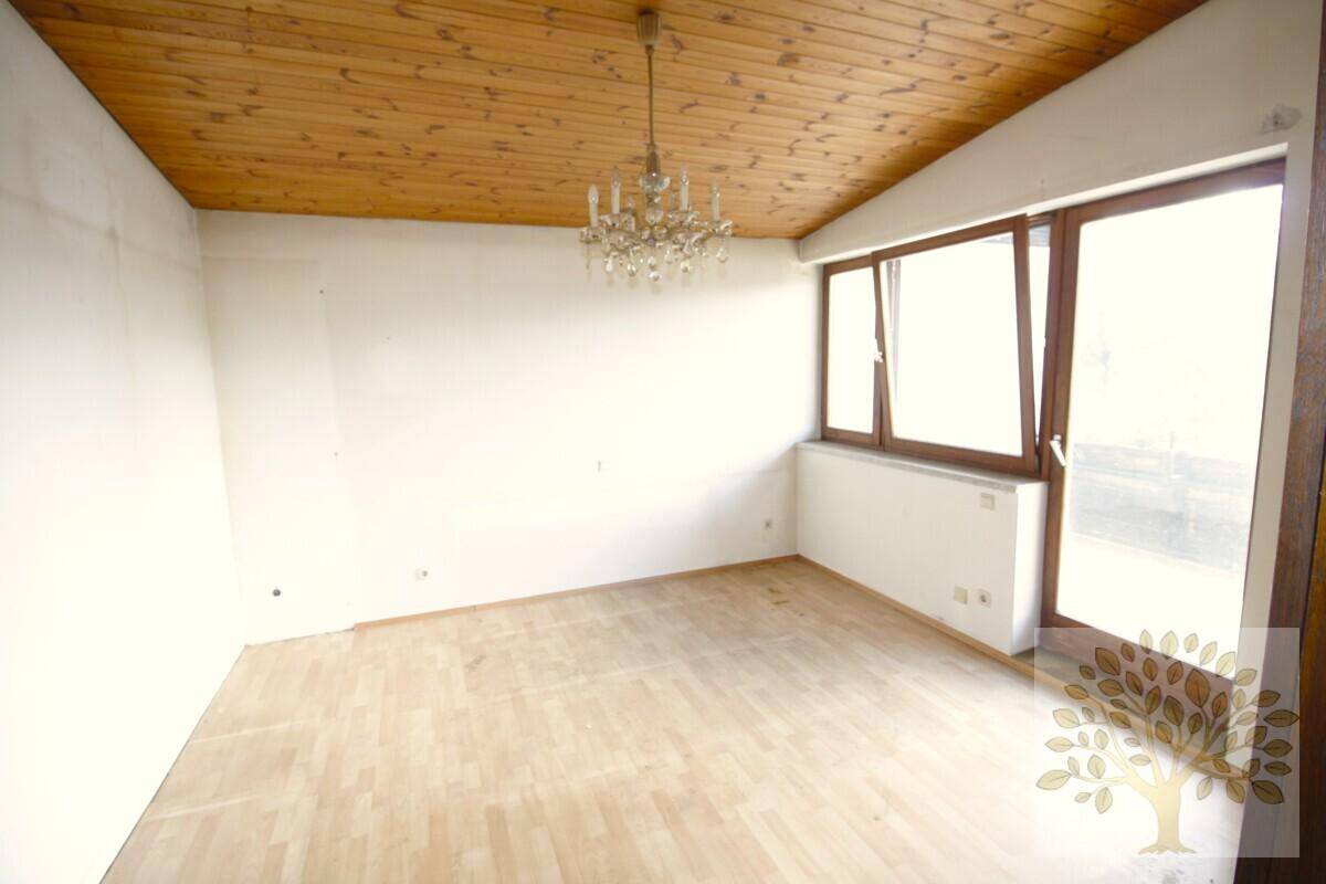 Helles Zimmer mit Holzparkettboden, Holzdecke und großen Fenstern, bereit zur Einrichtung.