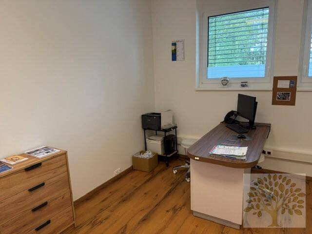 Funktionales Büro mit Schreibtisch, Drucker und Laminatboden, bietet eine angenehme Arbeitsatmosphäre.