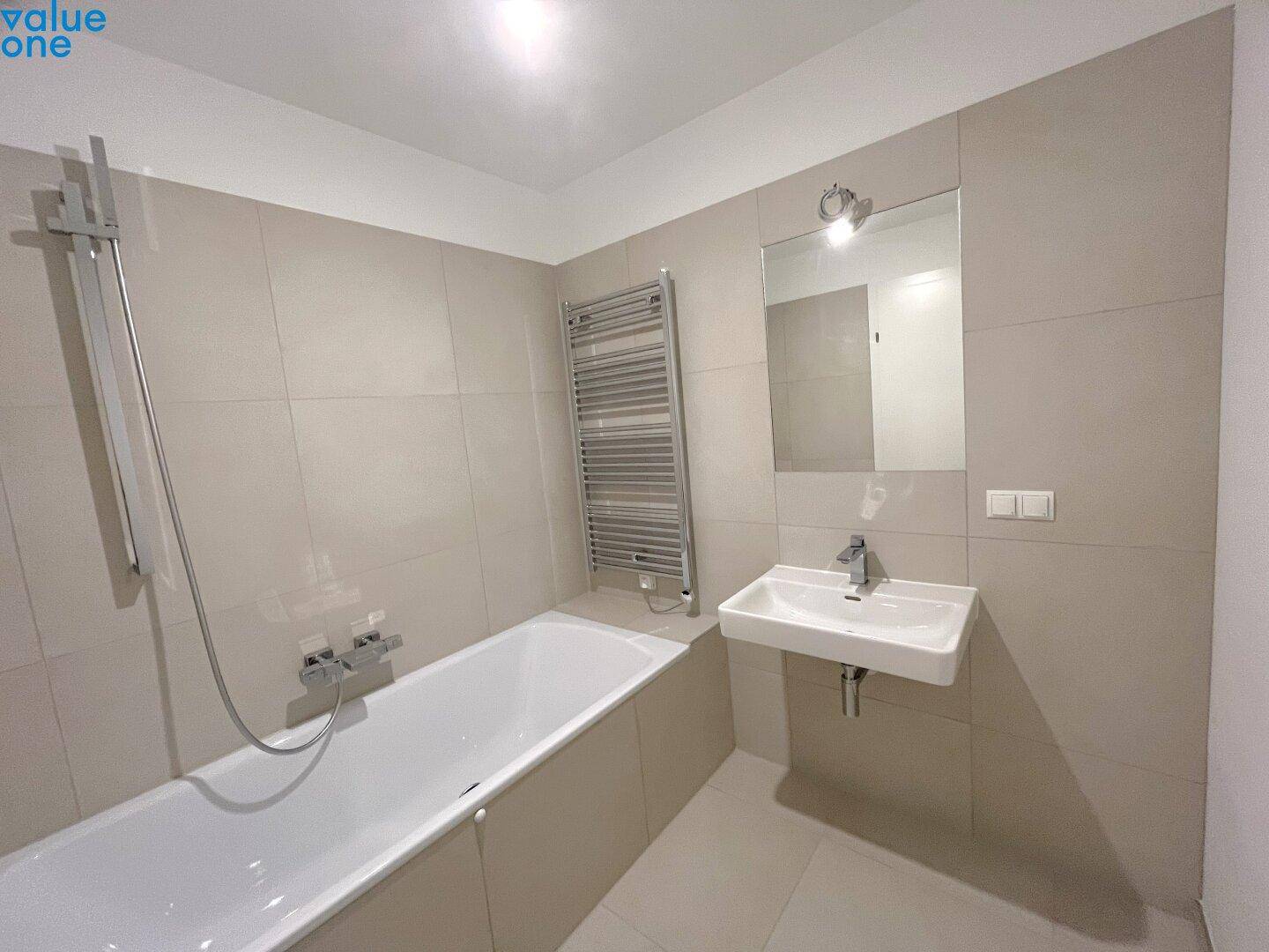 Modernes Badezimmer mit Badewanne, Duscharmatur und einem einzelnen Waschbecken.