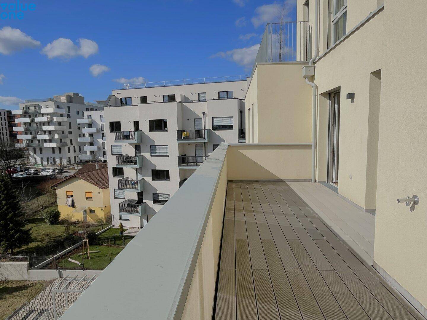 Sonniger Balkon mit weitem Blick auf die Nachbarschaft und weitere Wohngebäude.