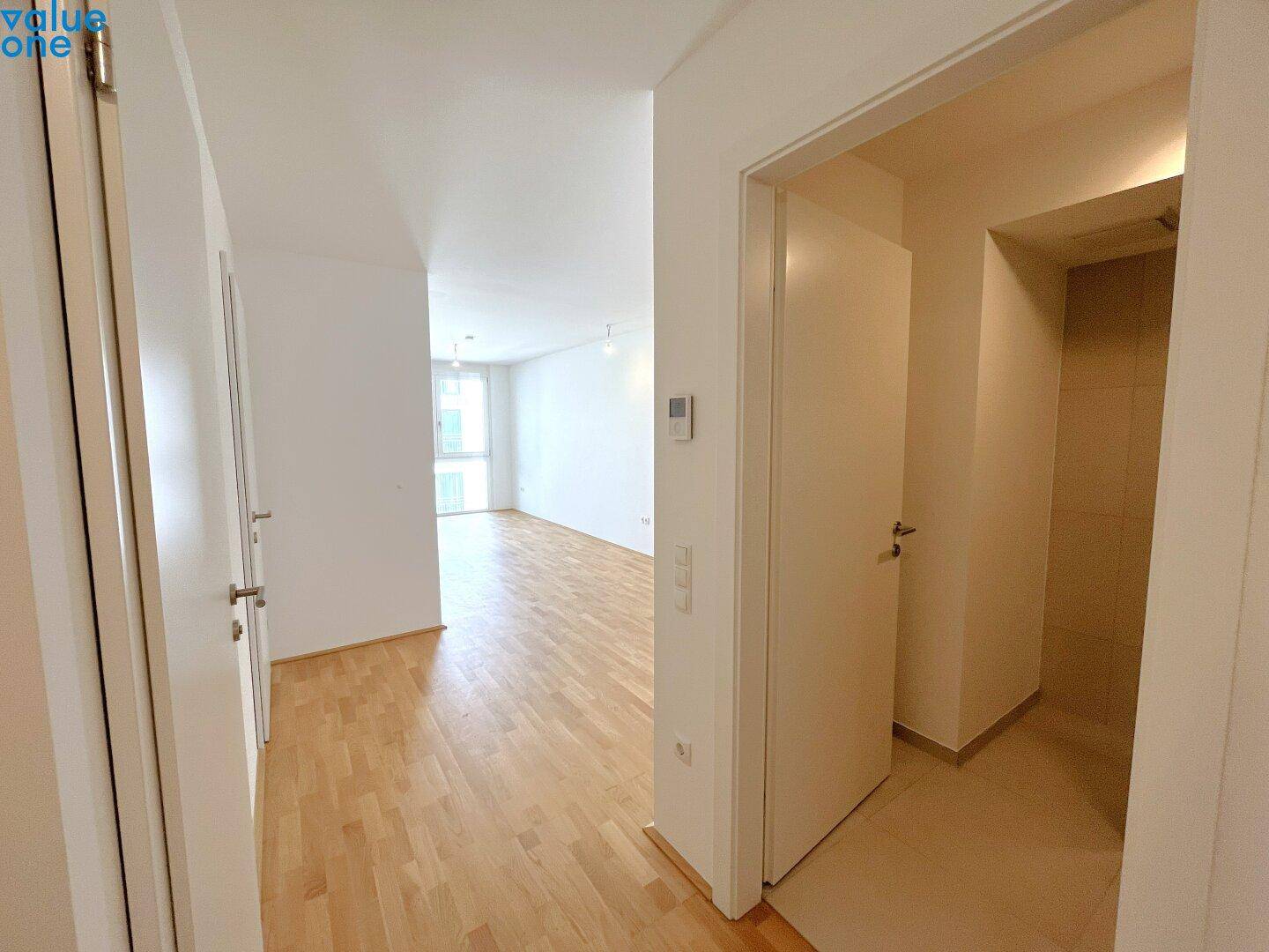 Heller Flur mit Parkettboden, der zu den verschiedenen Räumen der Wohnung führt.