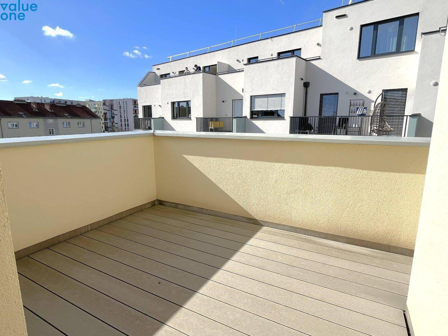 Leere Dachterrasse mit Holzdielenboden und weitem Blick über die Stadt.