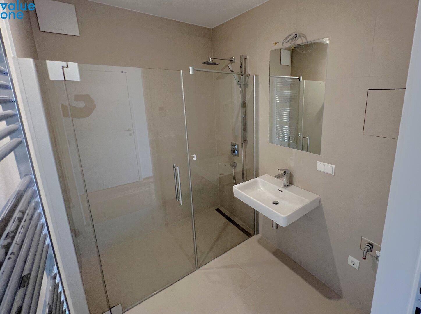 Modernes Badezimmer mit geräumiger Dusche und stilvollem Waschbecken.