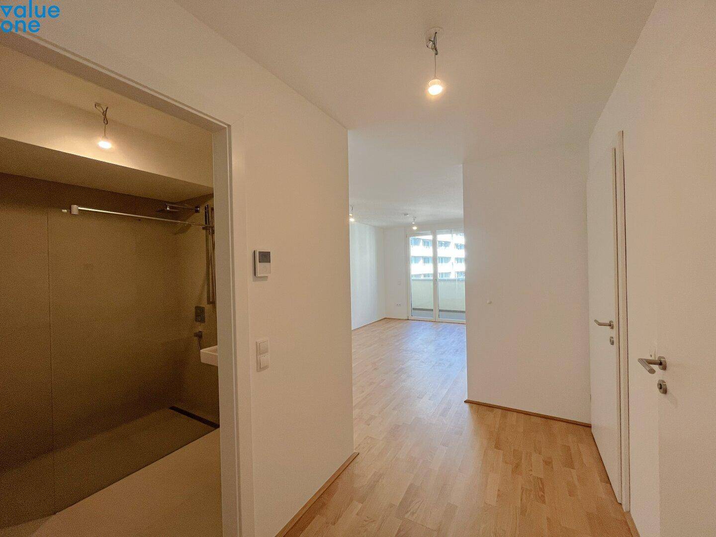 Heller Flur mit Parkettboden, der zu den verschiedenen Räumen der Wohnung führt.