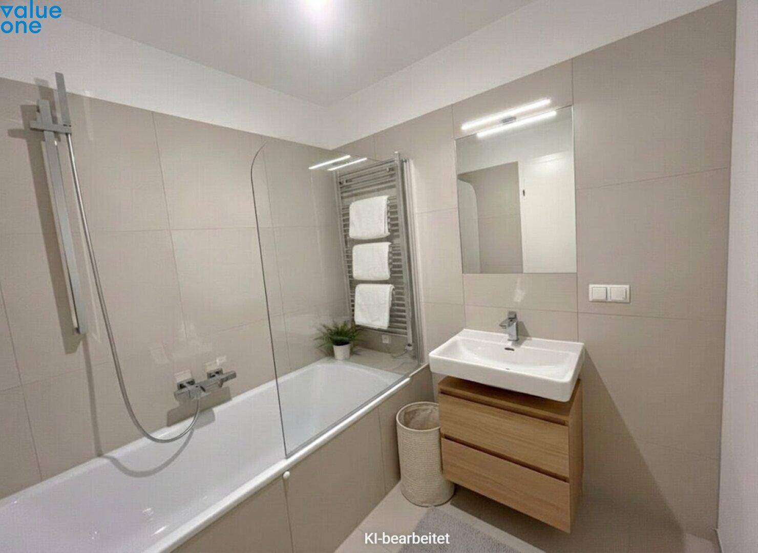 Modernes Badezimmer mit Badewanne, Duschwand, Einzelwaschbecken und beheiztem Handtuchhalter.