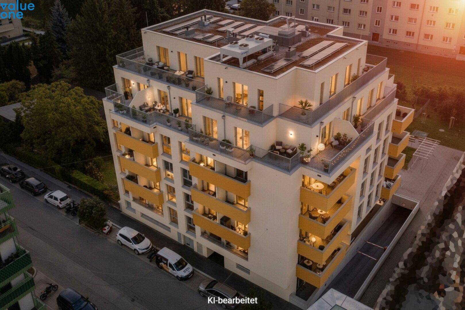 Moderne Wohnanlage mit mehreren Balkonen und Dachterrassen bei Sonnenuntergang.