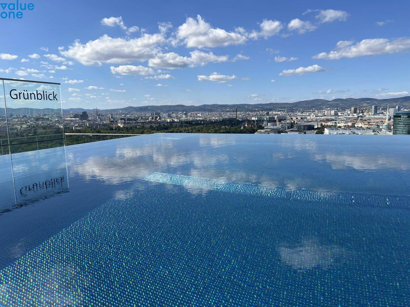 Infinity-Pool auf dem Dach mit atemberaubendem Blick auf die Stadt und die umliegende Landschaft.