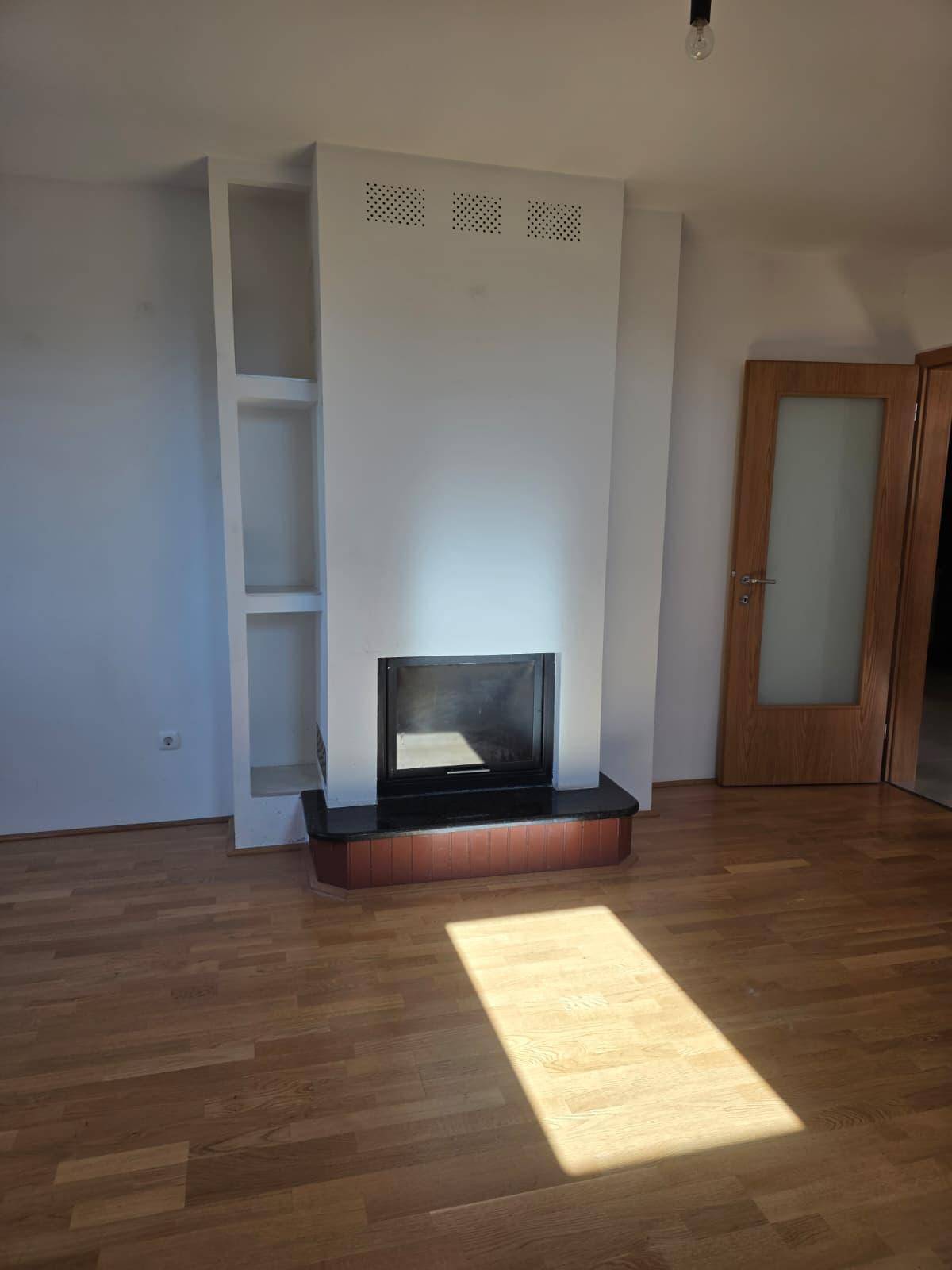 Moderner Kamin mit integrierten Regalen in einem hellen Wohnbereich mit Holzboden.